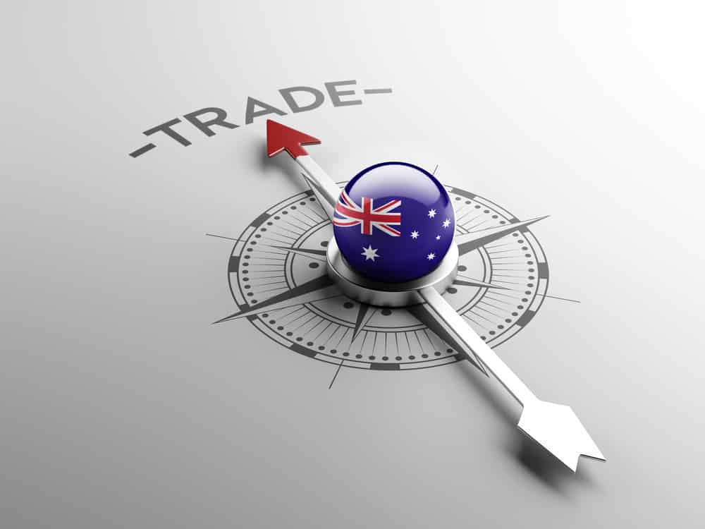 Image of a silver compass with an Australian flag in the centre, and the arrow pointing north toward the word ‘trade’ - symbolic of Australia focused on its new trade partnership with India