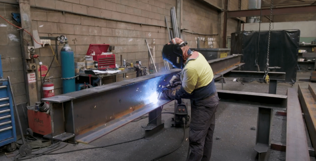  A welder in a factory works on a steel beam